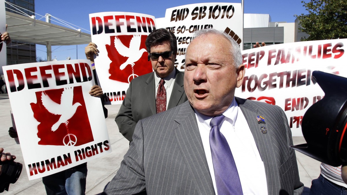 In this Feb. 10, 2011 file photo, protestors gather around Arizona State Sen. Russell Pearce, R-Mesa, Arizona's immigration bill SB1070 author, outside the Sandra Day O'Connor Federal Courthouse in Phoenix. (AP Photo/Matt York, File)