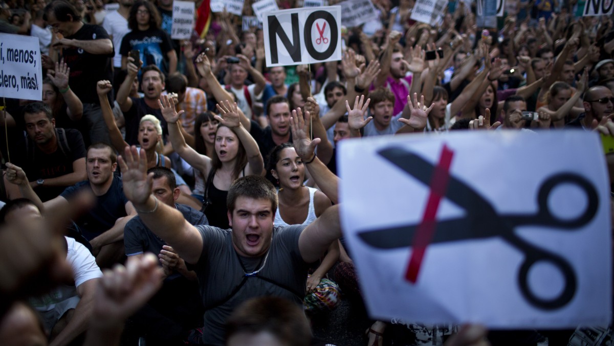 Demonstrators shout slogans condemning the recent austerity measures announced by the Spanish government, during a protest in front of the Popular Party in Madrid, Spain, Friday July 13, 2012. (AP Photo/Emilio Morenatti)