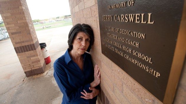 Linda Carswell poses at the Langham High School track by a memorial plaque for her husband. Her lobbying and testimony played a crucial role in the Jerry Carswell Memorial Act, a new informed consent for autopsies bill passed in Texas this year. (Sharon Steinmann/ProPublica)