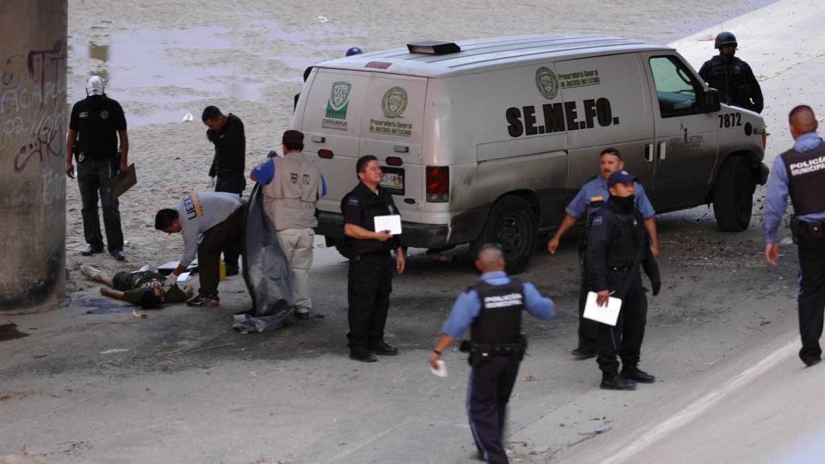 Mexican forensic experts examine the body of a boy under the Paso Del Norte border bridge in the city of Ciudad Juarez, Mexico on June 7, 2010. Officials released a statement demanding a full investigation into the deaths of victims allegedly shot by a U.S. Border Patrol agents. (AP Photo)