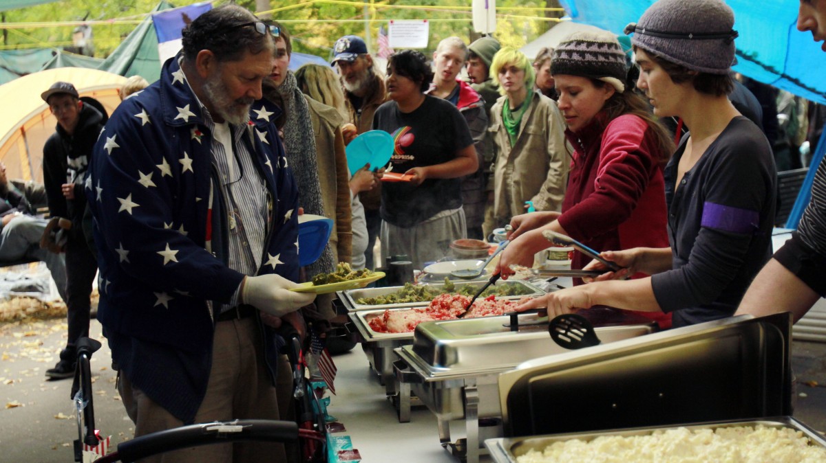 People line up for free lunch from Occupy Wall Street protesters. Demonstrators are camping out across the country are rubbing shoulders with the actual homeless, sharing shelter and in many cases free food and medical care. (AP Photo/Don Ryan)