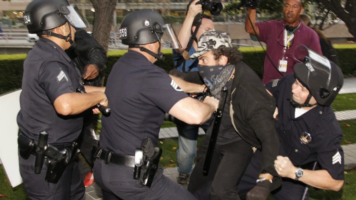 Some police officers struggle to arrest an unidentified person Thursday, Nov. 17, 2011. (AP Photo/Damian Dovarganes)