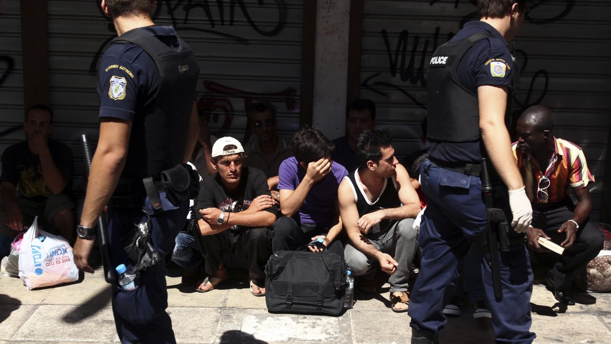 Police detain a group of migrants in central Athens, Sunday, Aug. 5, 2012. (AP Photo/Thanassis Stavrakis)