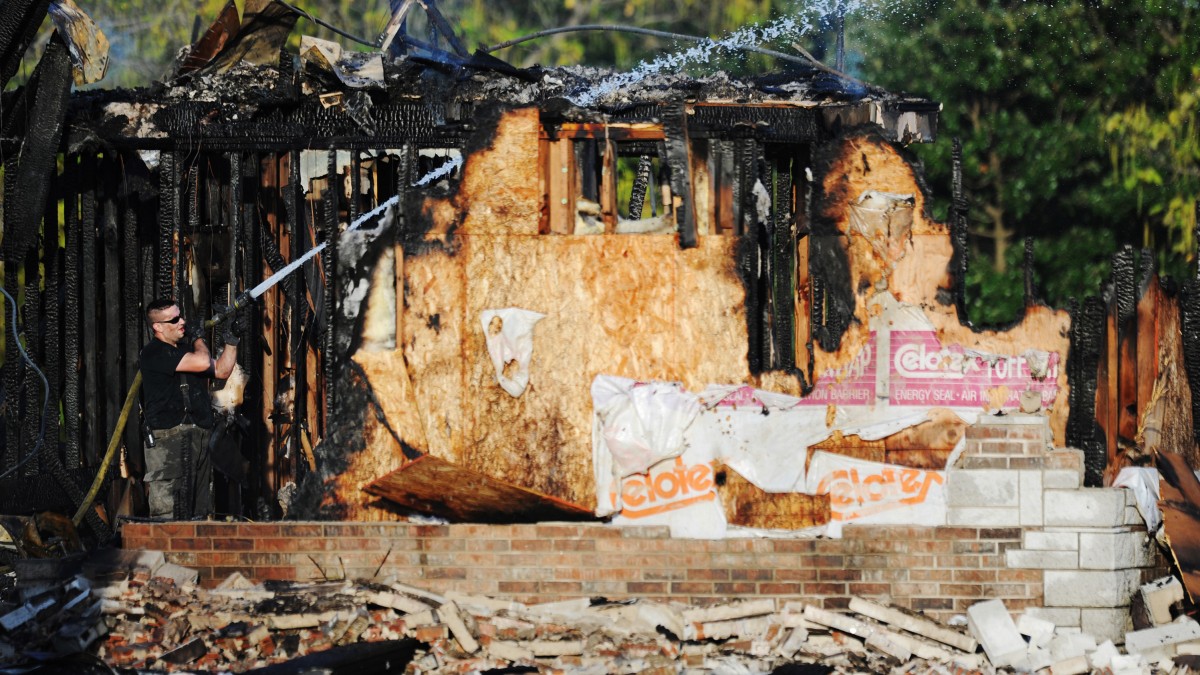 A Carl Junction, Mo., firefighter works to extinguish the smoldering remains of the Islamic Society of Joplin mosque, Monday, Aug. 6, 2012, in Joplin, Mo. The fire was the second fire to hit the Islamic center in little more than a month. (AP Photo/The Joplin Globe, T. Rob Brown) MANDATORY CREDIT