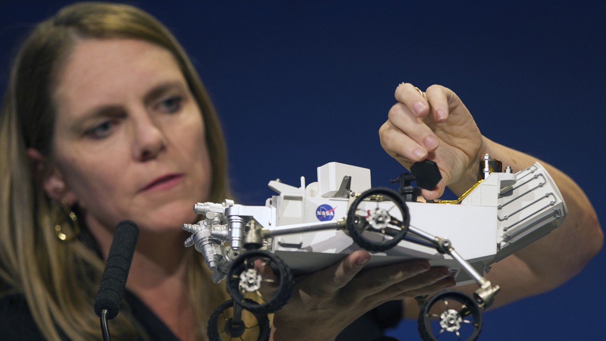 Jennifer Trosper, Mars Science Laboratory, MSL mission manager, JPL, adjusts the high-gain antenna on a rover model during a news briefing on the last data and imagery from Sol 1 at NASA's Jet Propulsion Laboratory in Pasadena, Calif., Monday, August 6, 2012. (AP Photo/Damian Dovarganes)