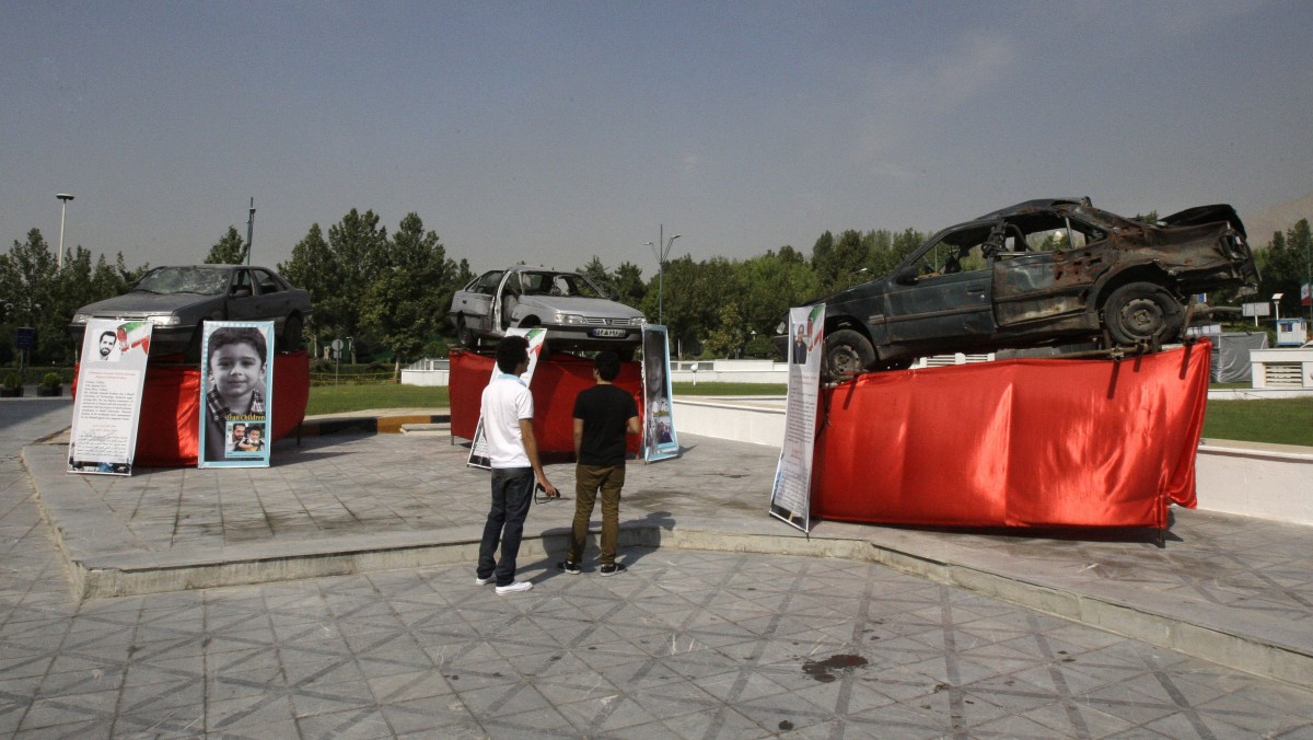 Damaged cars that three Iranian scientists, Masoud Ali Mohammadi, right, Majid Shahriari, center, and Mostafa Ahmadi Roshan, were riding in when they were killed in bombings over the last three years are displayed outside a conference hall hosting the meeting of Non-Aligned Movement, NAM, in Tehran, Iran, Sunday, Aug. 26, 2012. (AP Photo/Vahid Salemi)