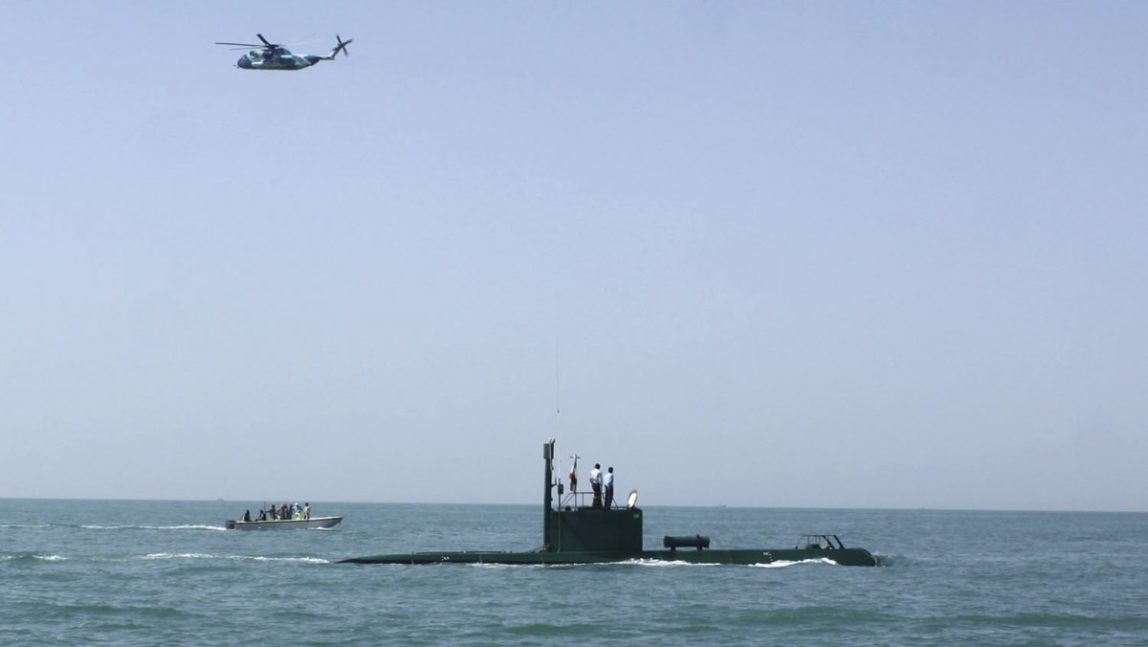 In this photo released by the semi-official Iranian Fars News Agency, and taken on Sunday, May 9, 2010, a helicopter flies over a submarine during Iranian naval maneuvers in the Oman Sea in a part of Iranian southern waters. (AP Photo/Fars News Agency, Hossein Zohrevand, File)