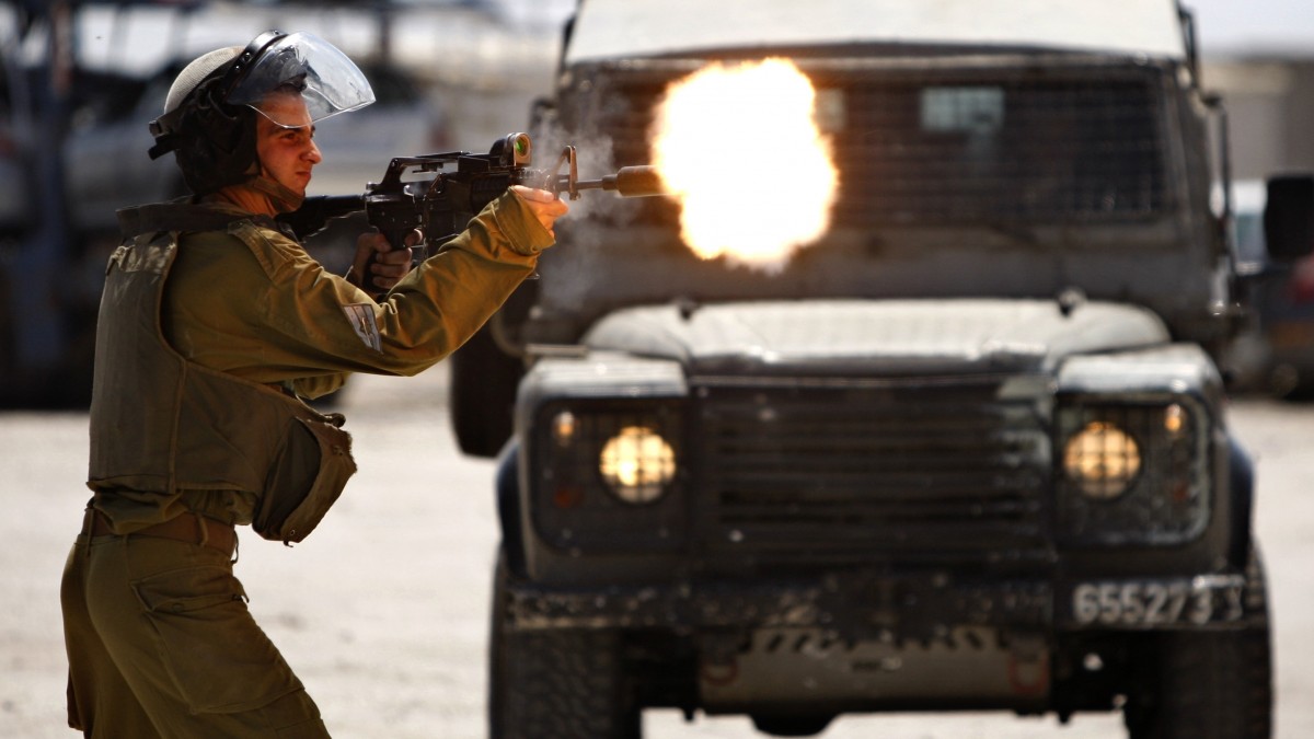 An Israeli Soldier shoots rubber bullets towards Palestinian protesters, not pictured, during a demonstration supporting prisoners in Israeli jails outside the Ofer military prison, near the West Bank city of Ramallah, Tuesday, Aug. 28, 2012. (AP Photo/Majdi Mohammed)