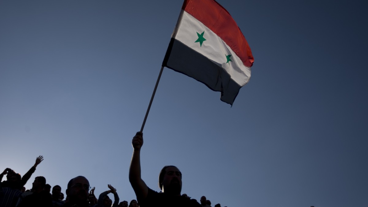 In this May 15, 2011 file photo, a Druse man waves a Syrian flag. (AP Photo/Ariel Schalit, File)