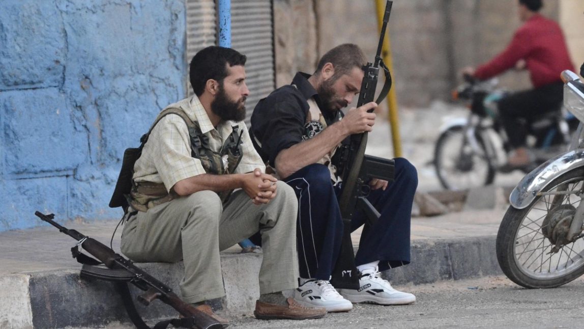 Free Syrian Army soldiers sit on a sidewalk at the northern town of Sarmada, in Idlib province, Syria, Wednesday, Aug. 1, 2012. (AP Photo)