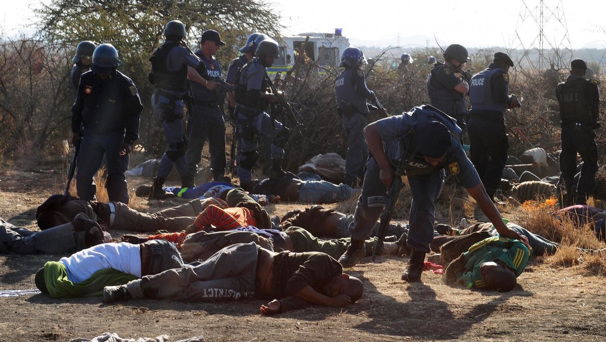 Police surround the bodies of striking miners after opening fire on a crowd at the Lonmin Platinum Mine near Rustenburg, South Africa, Thursday, Aug. 16, 2012. (AP Photo)