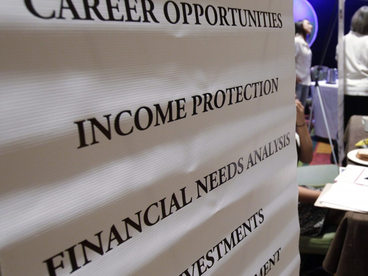 In this July 25, 2012 file photo, job seekers visit a Primerica booth at a job fair in San Jose, Calif. (AP Photo/Paul Sakuma, File)