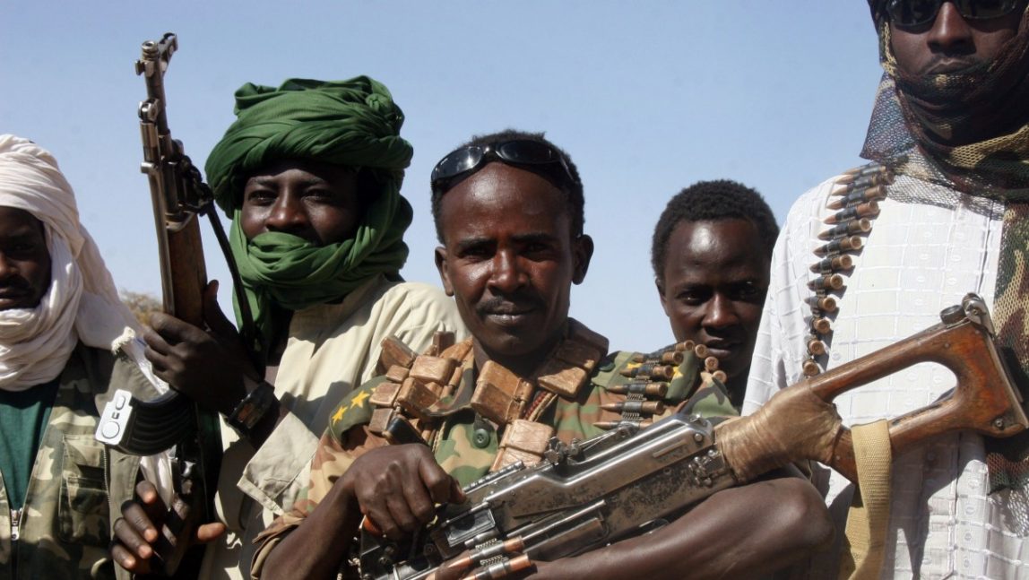 A section leader from the Sudan Liberation Army, center, wearing a captured Sudanese officer's uniform with three stars, and other rebels are pictured along the Chad-Sudan border on Saturday, Feb. 17, 2007. (AP Photo/Alfred de Montesquiou)