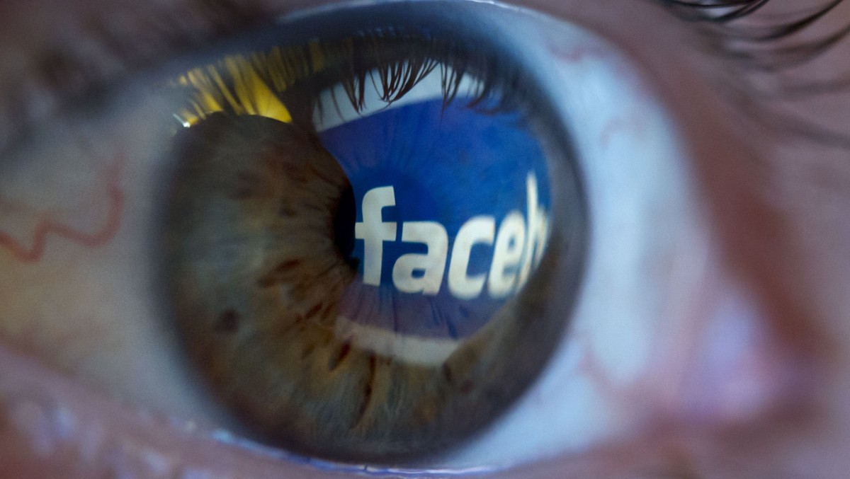 The logo of the social network "Facebook" is reflected in the pupil of an eye. (Photo: Joerg Koch / DAPD)
