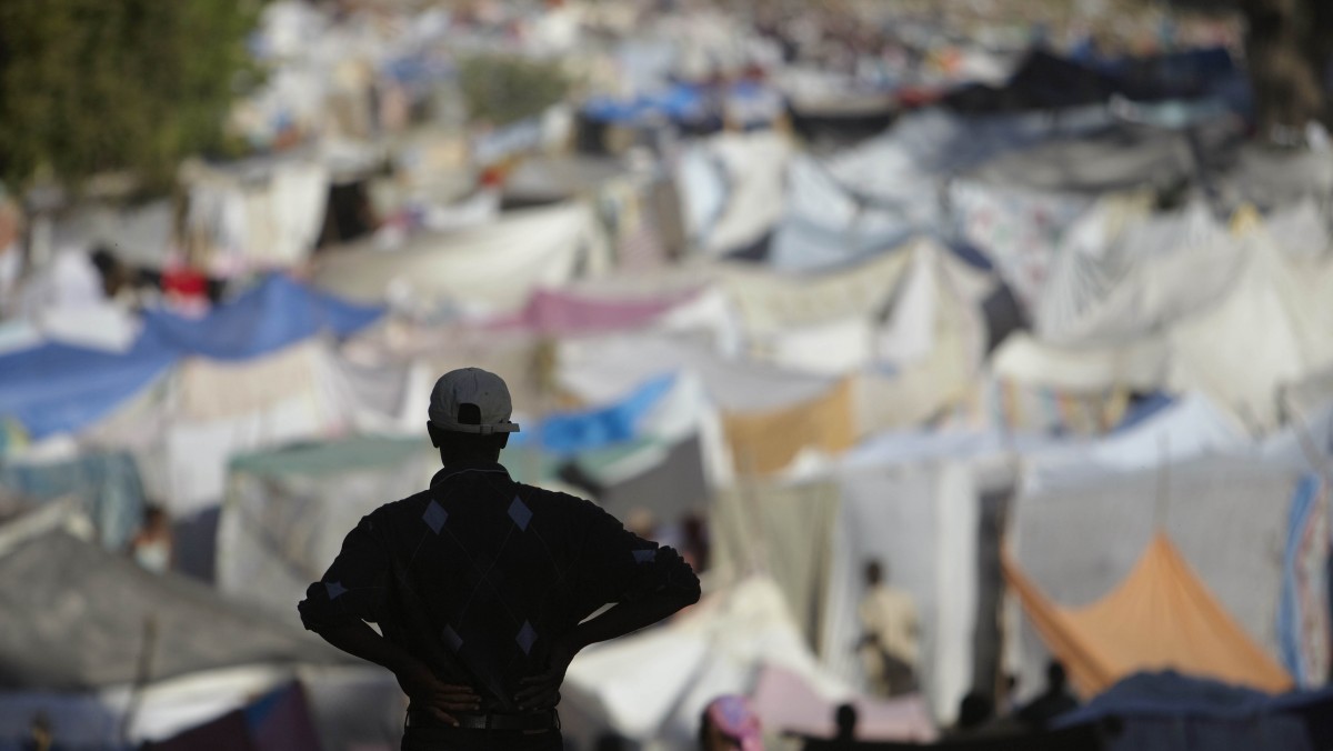A man looks out over makeshift tents at a refugee camp. (AP Photo/Gregory Bull)