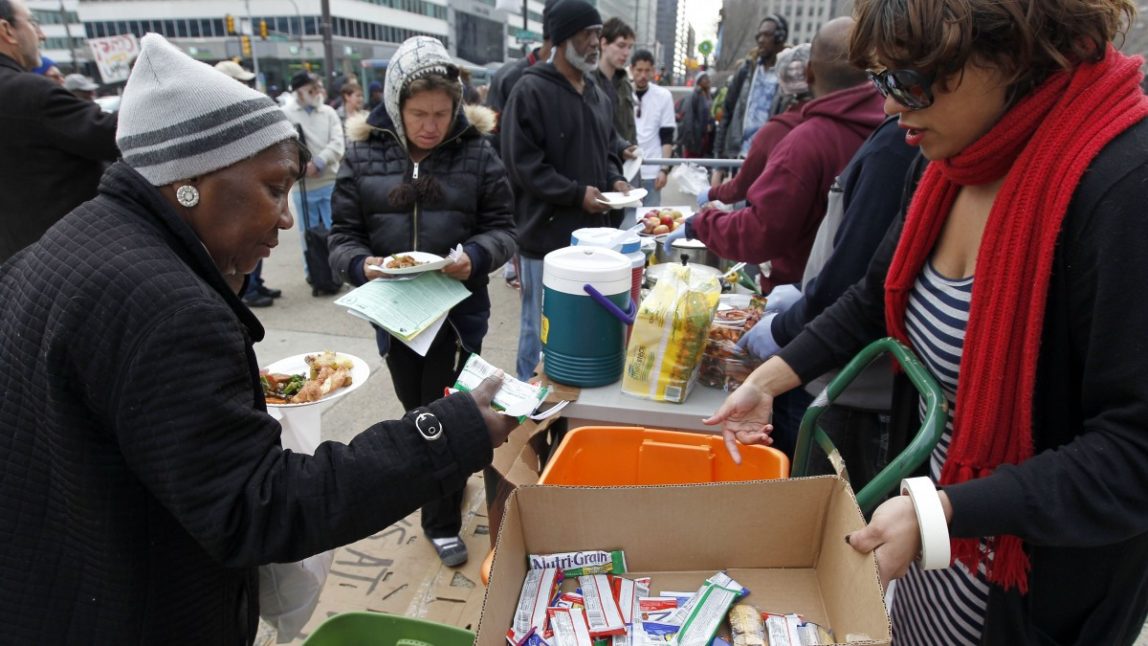 People receive food in front of the building before a Philadelphia Department of Public Health hearing regarding regulations banning outdoor food distribution Thursday, March 15, 2012 in Philadelphia. (AP Photo/Alex Brandon)