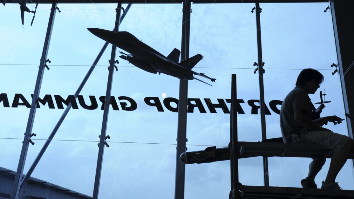 In this Feb. 15, 2008 file photo, a contractor is silhouetted while assembling model planes in the exhibition booth of Northrop Grumman at the site of the Singapore Airshow. (AP Photo/Wong Maye-E, File)