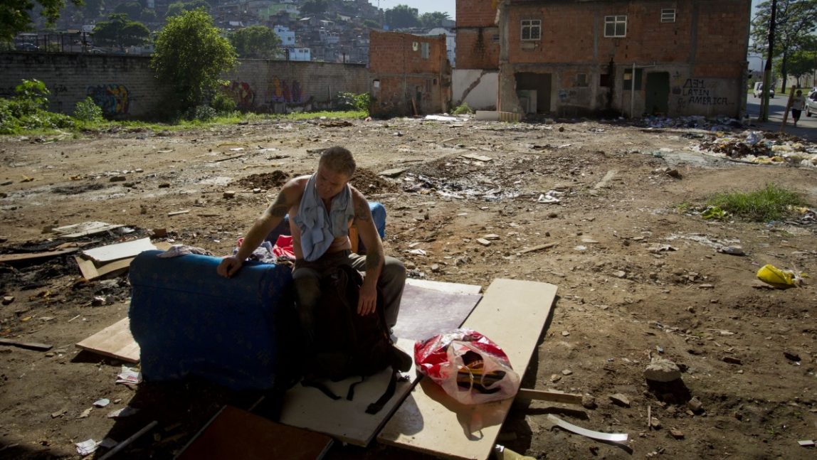 A homeless man sits on a sofa where houses were demolished in the Favela do Metro shantytown in Rio de Janeiro, Brazil, Wednesday, Feb. 1, 2012. Residents of communities like Metro, located on the surroundings of the Maracana stadium, are being pushed out of their homes to make way for new roads, Olympic venues, and other projects as part of preparations to host the 2014 World Cup and the 2016 Olympics. (AP Photo/Victor R. Caivano)