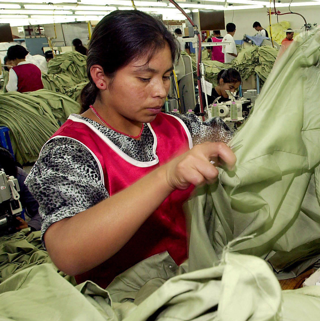An unidentified woman works at a sweatshop Tuesday, Oct. 2, 2001. (AP Photo/Jaime Puebla)