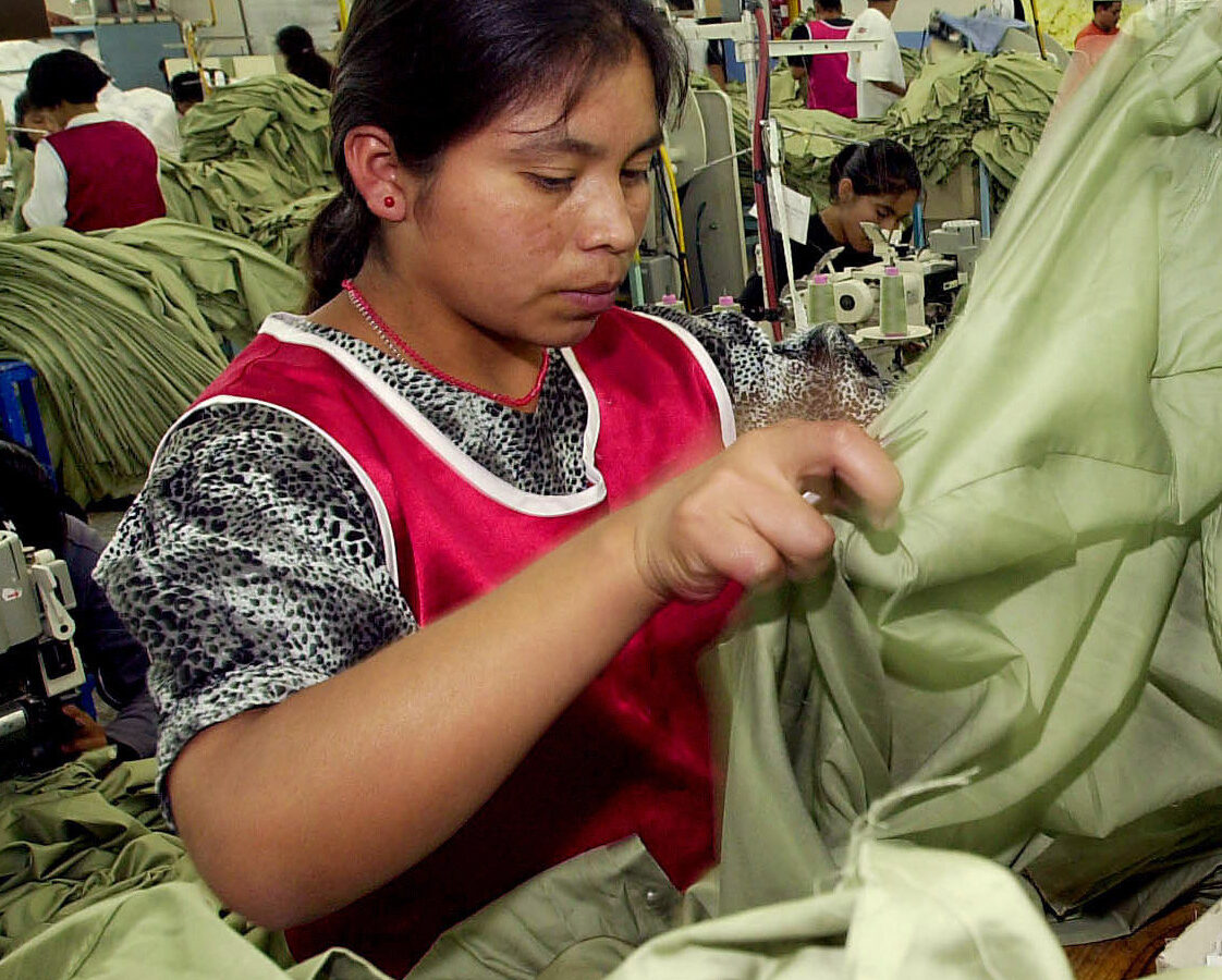 An unidentified woman works at a sweatshop Tuesday, Oct. 2, 2001. (AP Photo/Jaime Puebla)