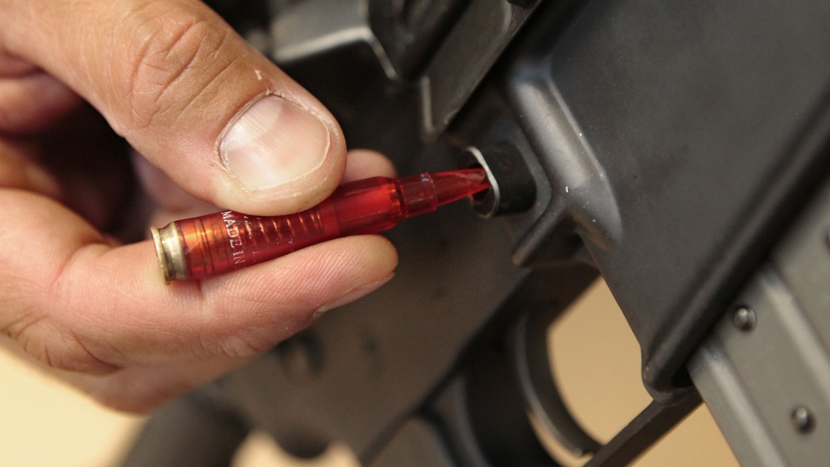 In this photo taken Wednesday, Aug. 15, 2012, a plastic replica of a bullet is used to quickly remove a ammunition magazine from an assault rifle in a demonstration at the California Department of Justice in Sacramento, Calif. (AP Photo/Rich Pedroncelli)