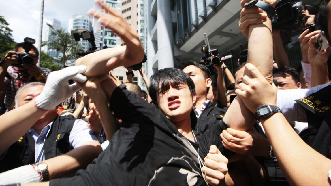 Bailiffs evict the protester the Asian headquarters of HSBC in Hong Kong, Tuesday, Sept. 11, 2012. (AP Photo/Kin Cheung)