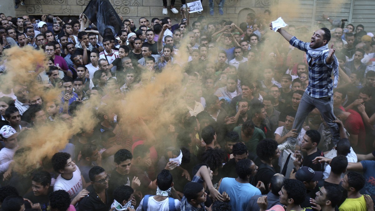 Protesters chant slogans amid orange smoke outside the U.S. embassy in Cairo, Egypt, Tuesday, Sept. 11, 2012. (AP Photo/Mohammed Abu Zaid)