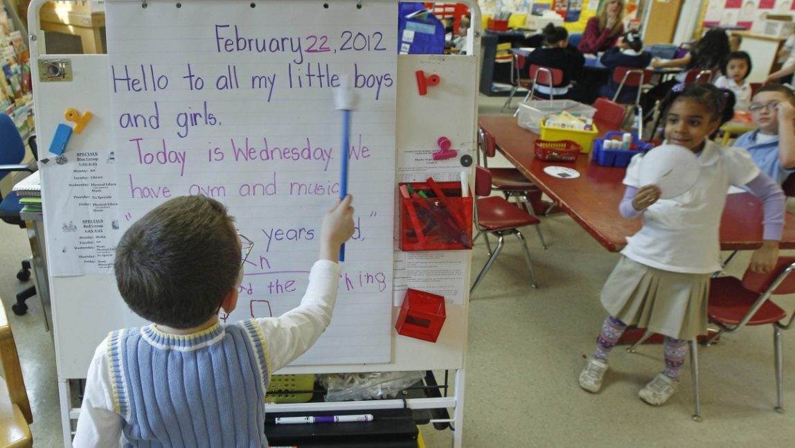 Ian Moore reads the daily message board in a kindergarten class at the Diloreto Magnet School in New Britain, Conn., Wednesday Feb. 22, 2012. (AP Photo/Charles Krupa)