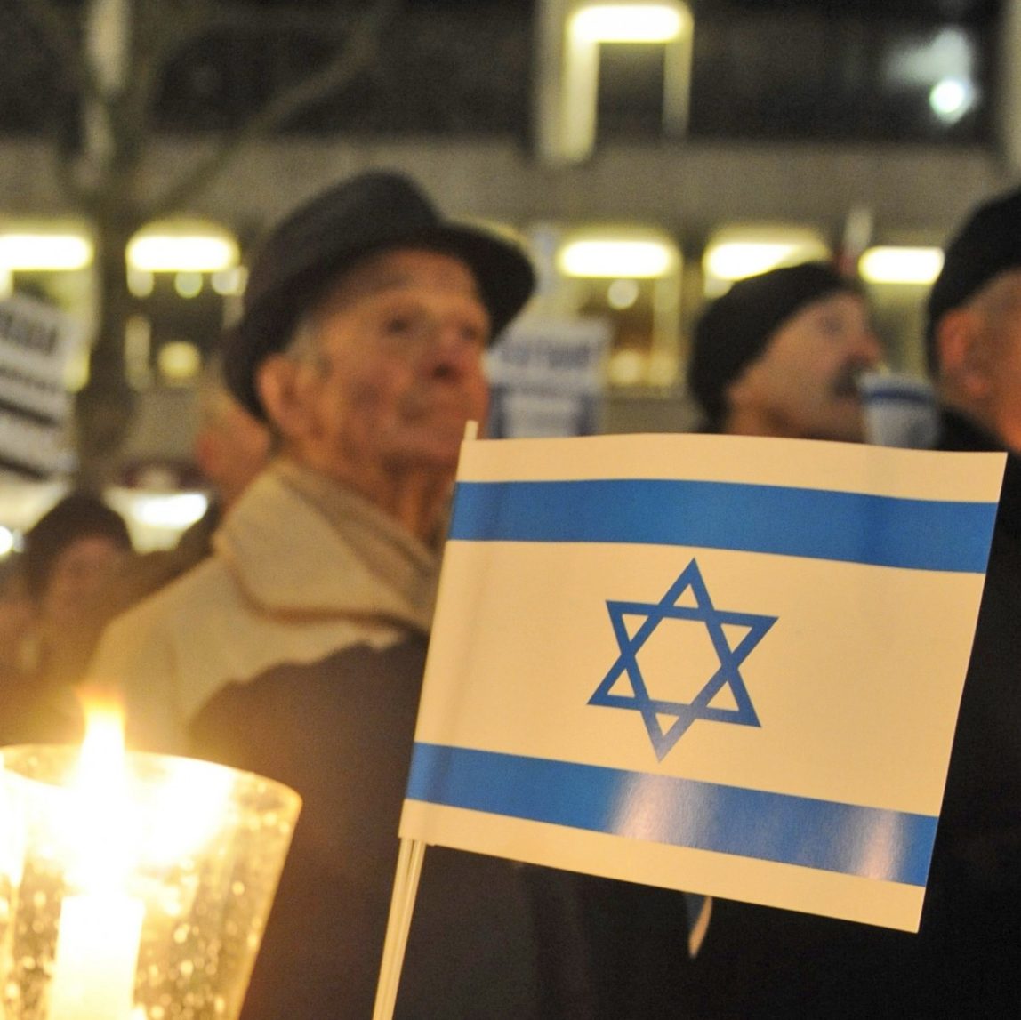A woman holds a candle and an Israeli flag during a pro-Israel demonstration. (AP Photo/Fabian Bimmer)