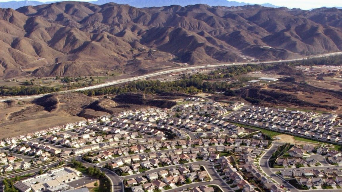 Interstate 15 cuts between homes and mountains in Corona, Calif., Thursday, Dec. 5, 2002, in Riverside County, which is part of the fast-growing Inland Empire. (AP Photo/Ric Francis)