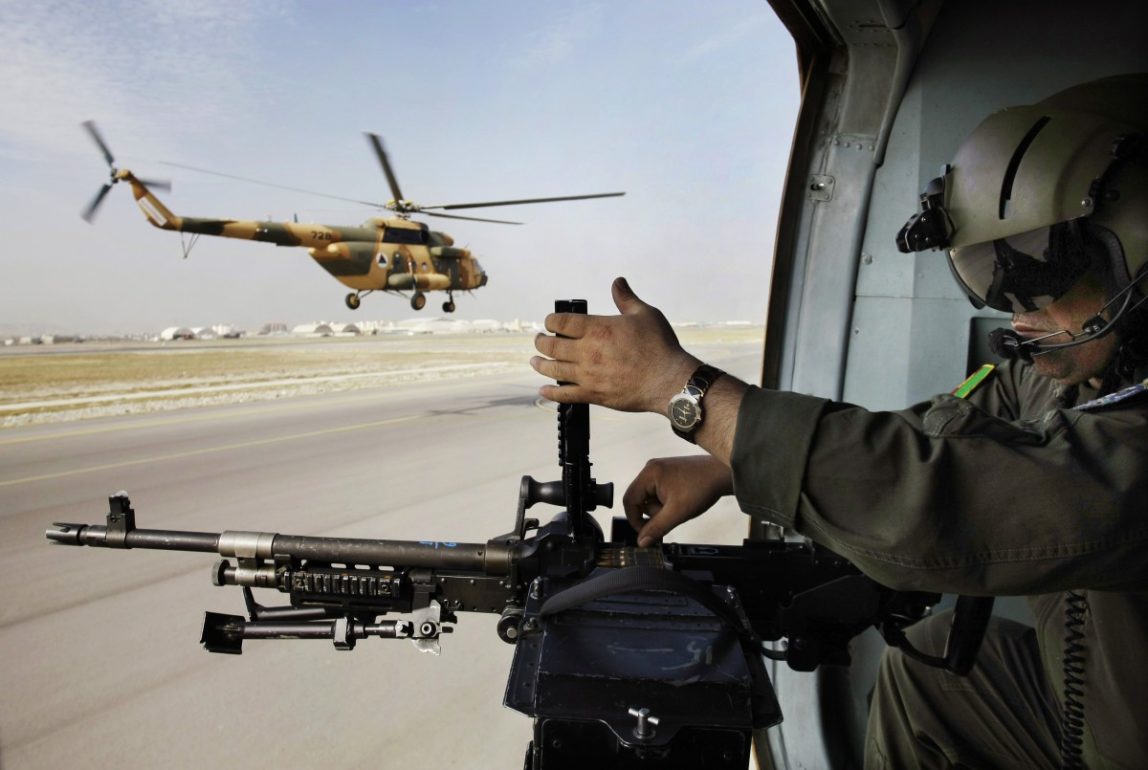 An Afghan soldier adjusts bullets in his gun on a military helicopter during a flight transporting journalists from Kabul to Bagram to attend the hand over ceremony of U.S.- run prison to Afghan government in Bagram north of Kabul, Afghanistan, Monday, Sept. 10, 2012. (AP Photo/Musadeq Sadeq)