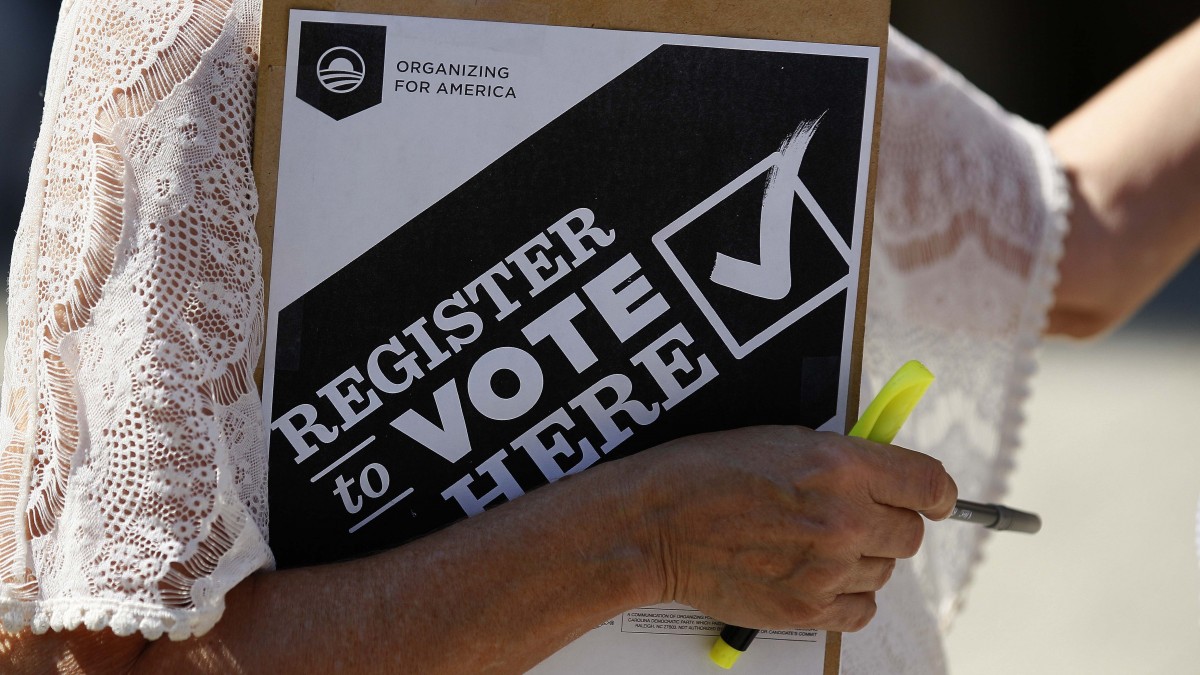 In this photo taken Wednesday, Sept. 26, 2012, campaign volunteer Barbara Smalley-McMahan, clutches her pad while attempting to register voters in downtown Raleigh, N.C. (AP Photo/Gerry Broome)