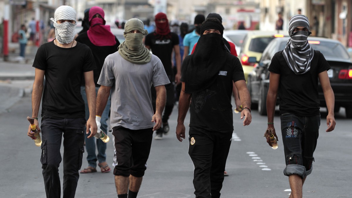 Masked Bahraini anti-government protesters carry petrol bombs ahead of a march in Malkiya, Bahrain, on Sunday, Oct. 28, 2012, where marchers were calling for freedom for political prisoners and honoring those killed in the uprising from Bahrain's western villages. (AP Photo/Hasan Jamali)