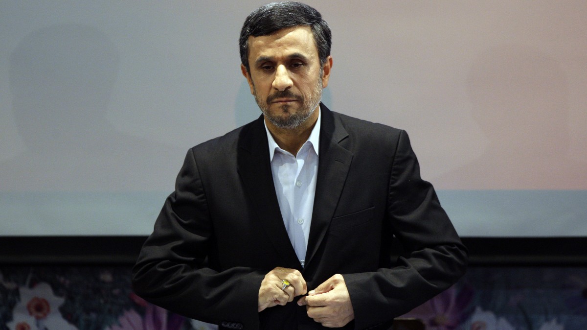 Iranian President Mahmoud Ahmadinejad adjusts his jacket as he listens to the Iranian national anthem at the start of a press conference in Tehran, Iran, Tuesday, Oct. 2, 2012. (AP Photo/Vahid Salemi)