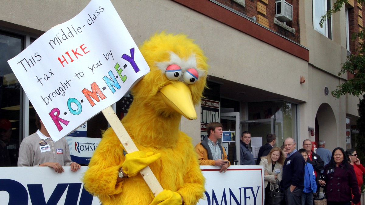 A person dressed up as Big Bird holds a sign against Republican presidential candidate, former Massachusetts Gov. Mitt Romney outside the Romney headquarters, Monday, Oct. 8, 2012 in Derry, N.H. where House Speaker John Boehner of Ohio was about to speak to supporters. (AP Photo/Jim Cole)