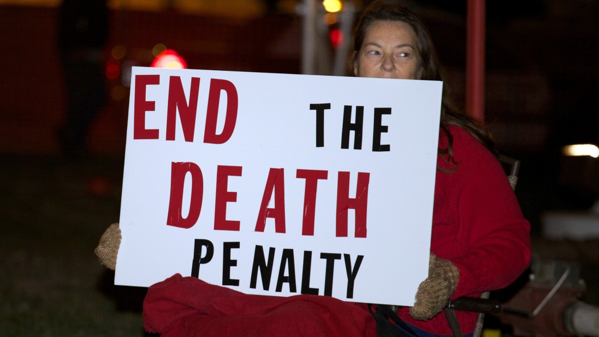 Death-penalty opponent Elaine Engelgau holds a sign during a protest outside the South Dakota Penitentiary in Sioux Falls, S.D., on Monday, Oct. 15, 2012, in anticipation of the execution of Eric Robert. Robert pleaded guilty in the April 12, 2011, slaying of a guard during a failed prison escape and asked to be put to death, saying he would kill again. (AP Photo/Amber Hunt)