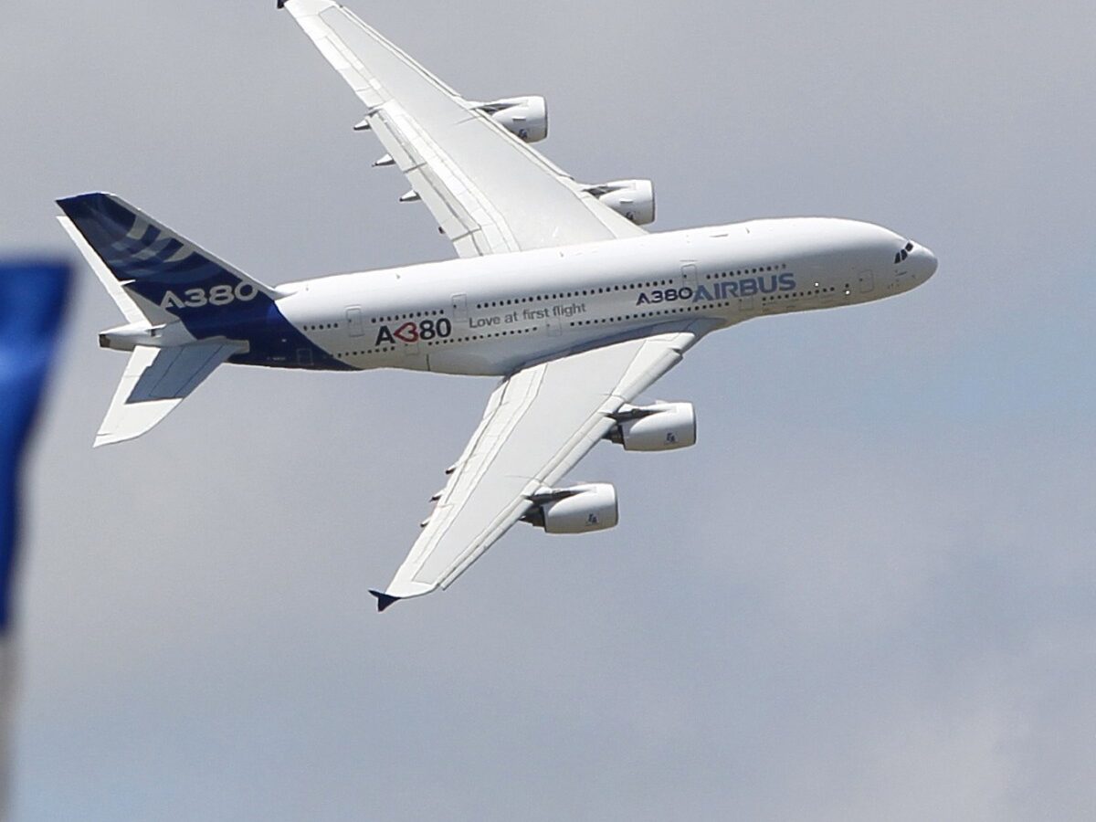 The June 25, 2011 file photo shows a Boeing flag fluttering as an Airbus A380 flies past during a demonstration flight at the 49th Paris Air Show at Le Bourget airport, east of Paris. (AP Photo/Francois Mori)