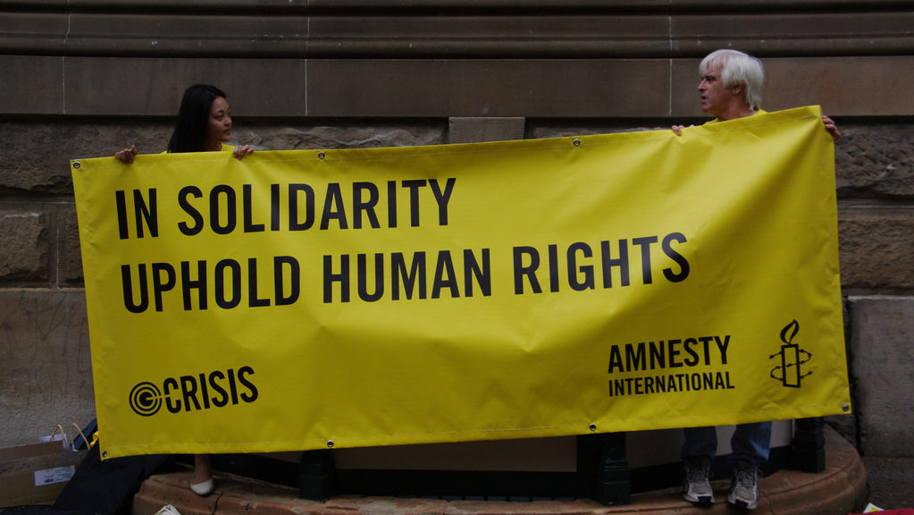Amnesty International supporters hold a banner in this Feb. 12, 2011 photo. (Photo by Richard Potts via Flikr)