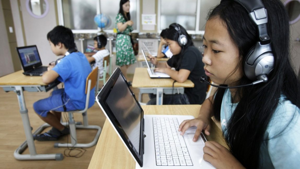 In this Friday, July 15, 2011 photo, a student and her schoolmates using tablet PCs take a lesson at an elementary school. (AP Photo/Ahn Young-joon)