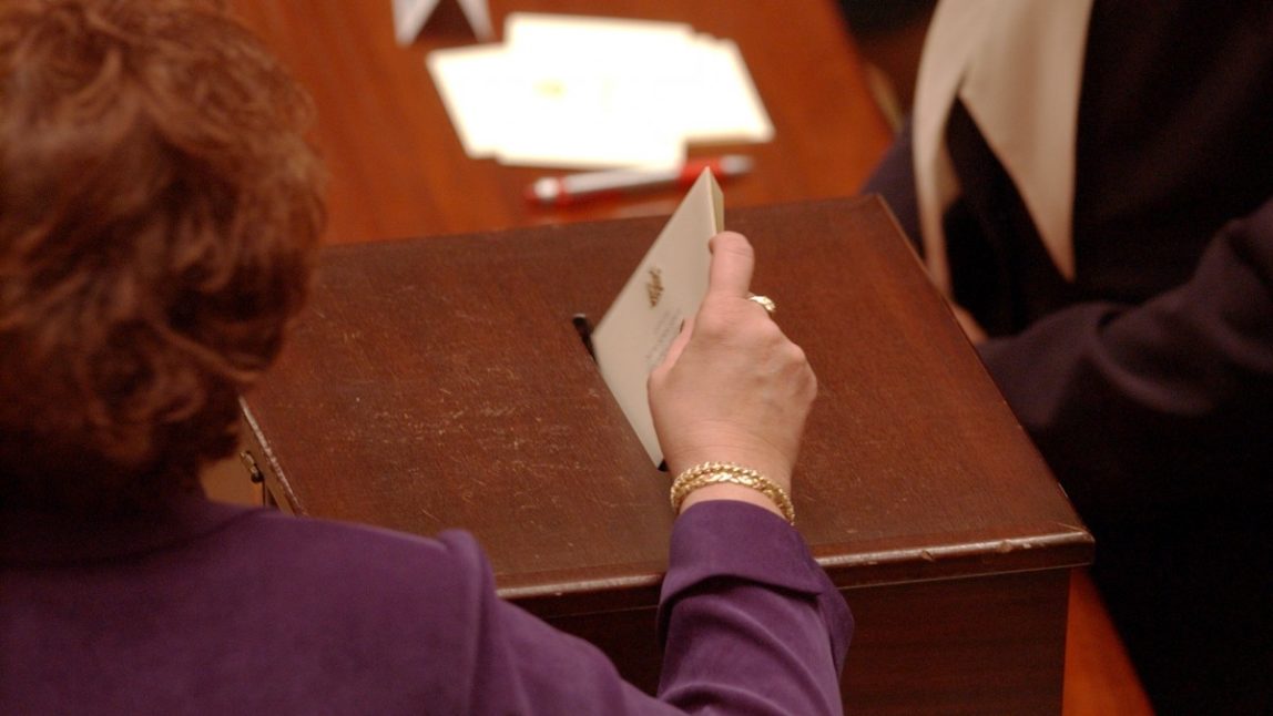 June O'Neill of St. Lawrence County places her vote for president in the ballot box on Monday, Dec. 13, 2004, in the Senate Chamber at the Capitol in Albany, N.Y., as the Electoral College for the State of New York voted for president and vice president. (AP Photo/Jim McKnight)