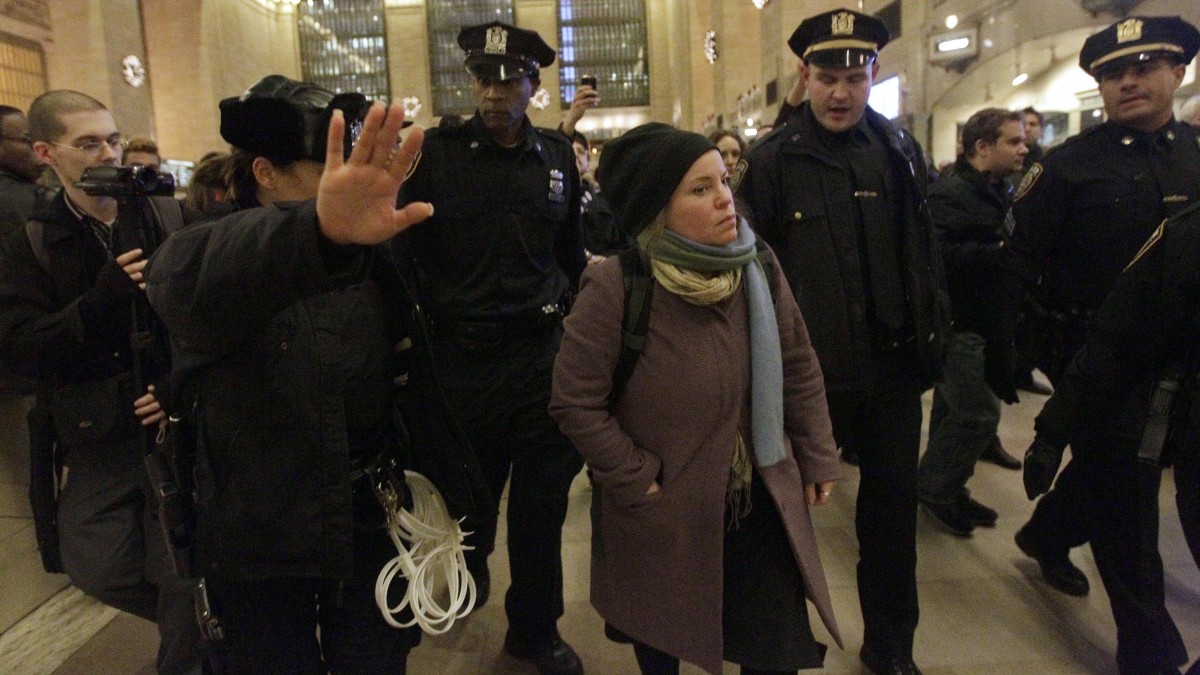An Occupy Wall Street protester is escorted out of the main waiting area by police officers during a demonstration in New York's Grand Central Station, Tuesday, Jan. 3, 2012. About a hundred Occupy Wall Street protesters rallied in New York City's Grand Central Station to call attention to a law signed by President Barack Obama that they say represses civil liberties. Obama signed the National Defense Authorization Act into law on New Year's Eve in 2012. (AP Photo/Mary Altaffer)