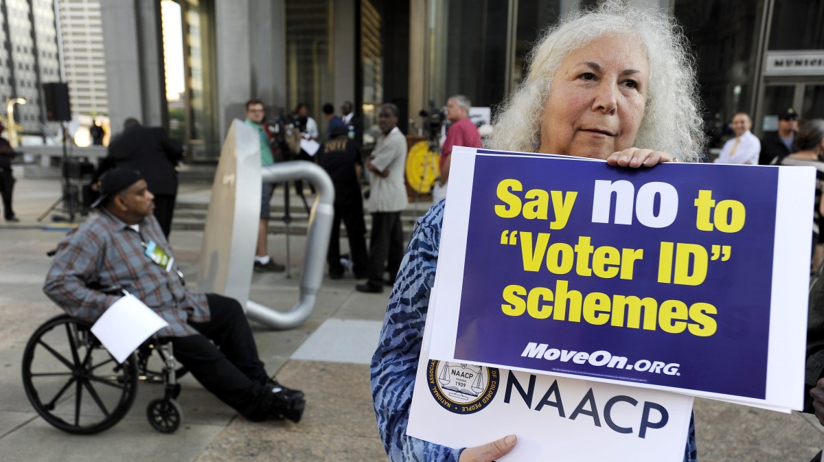 Gloria Gilman holds a sign during the NAACP voter ID rally to demonstrate the opposition of Pennsylvania's new voter identification law, Thursday, Sept. 13, 2012, in Philadelphia. (AP Photo/Michael Perez)