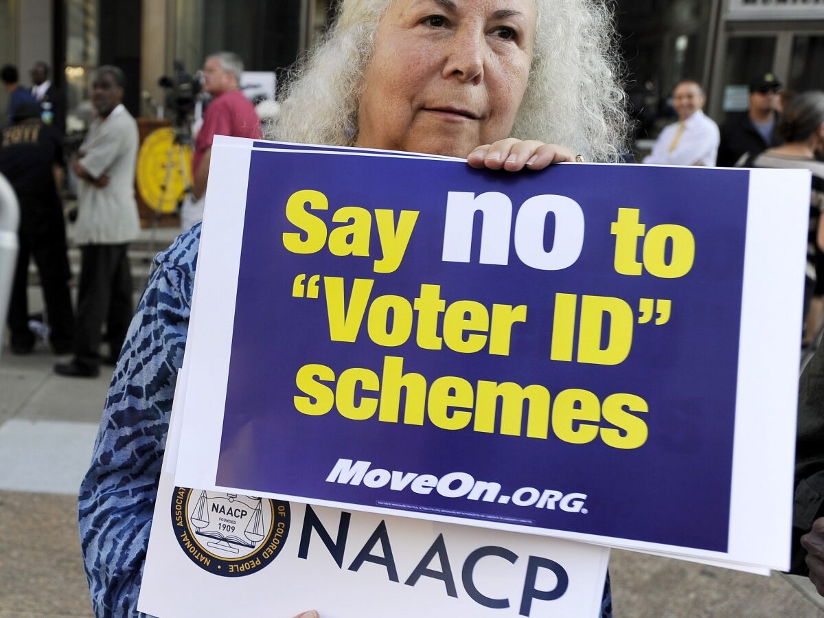 Gloria Gilman holds a sign during the NAACP voter ID rally to demonstrate the opposition of Pennsylvania's new voter identification law, Thursday, Sept. 13, 2012, in Philadelphia. (AP Photo/Michael Perez)