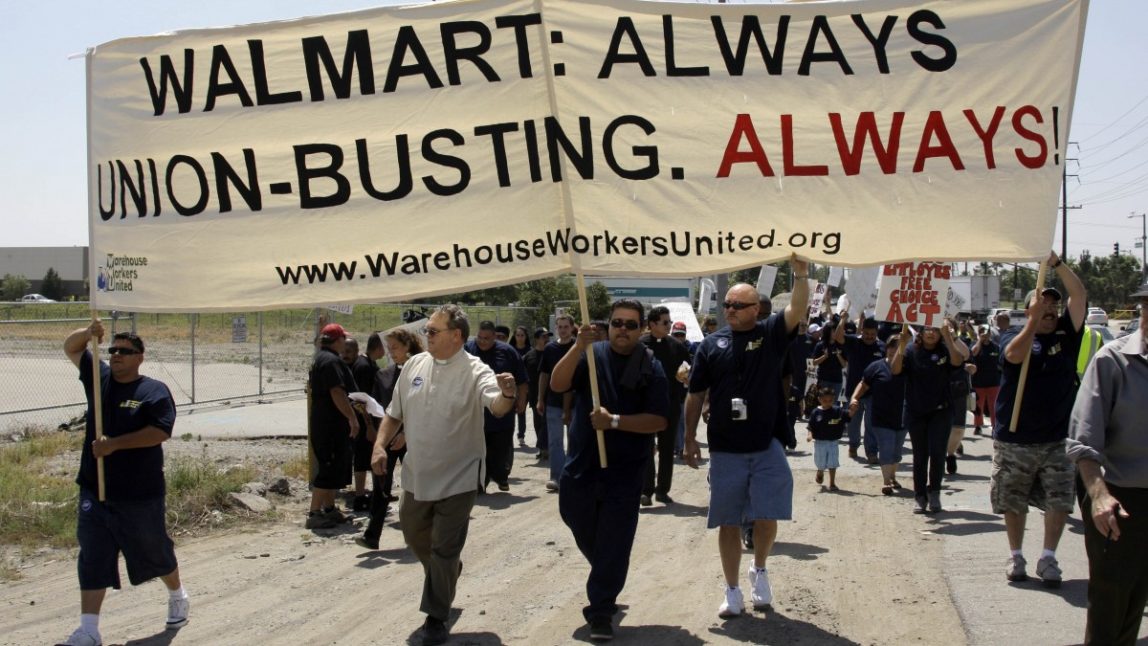 About 100 demonstrators march down a highway as union organizers, clergy, students and others demonstrate at a Walmart distribution center in Fontana, Calif., Thursday, April 14, 2009. (AP Photo/Reed Saxon)