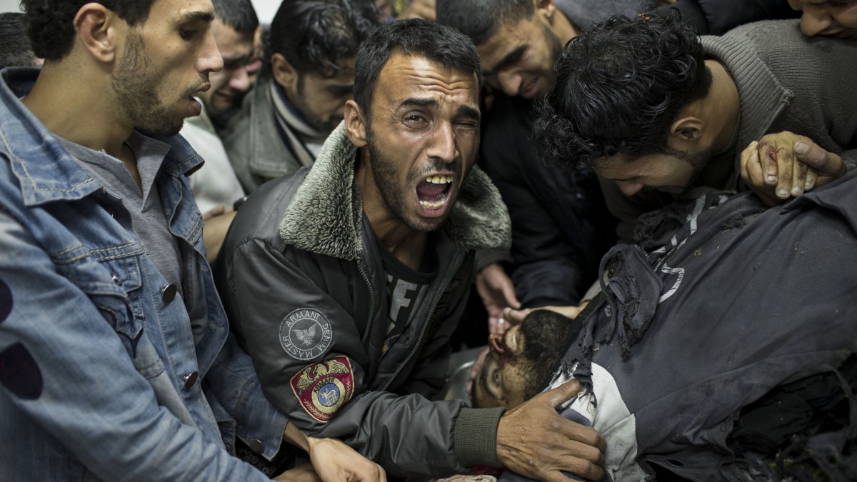 A Palestinian man cries next the body of a dead relative in the morgue of Shifa Hospital in Gaza City, Sunday, Nov. 18, 2012. (AP Photo/Bernat Armangue)