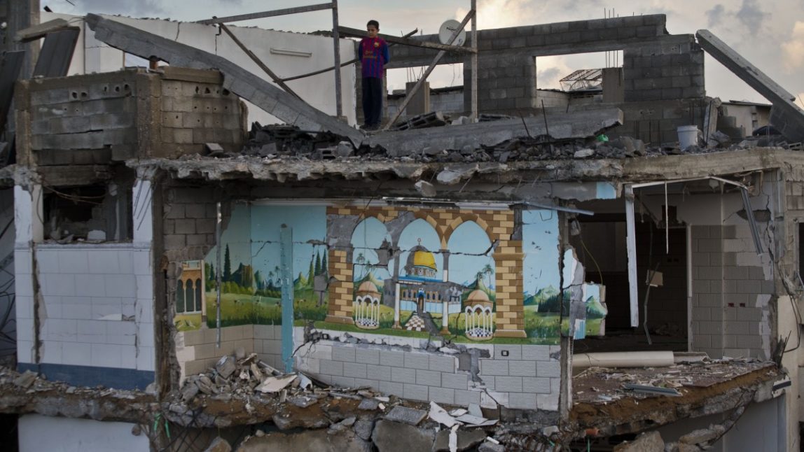 A Palestinian boy looks from the rooftop of a destroyed house in Gaza City, Sunday, Nov. 25, 2012. (AP Photo/Bernat Armangue)
