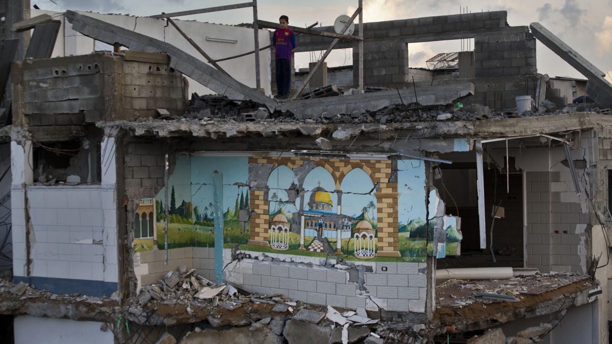 A Palestinian boy looks from the rooftop of a destroyed house in Gaza City, Sunday, Nov. 25, 2012. (AP Photo/Bernat Armangue)