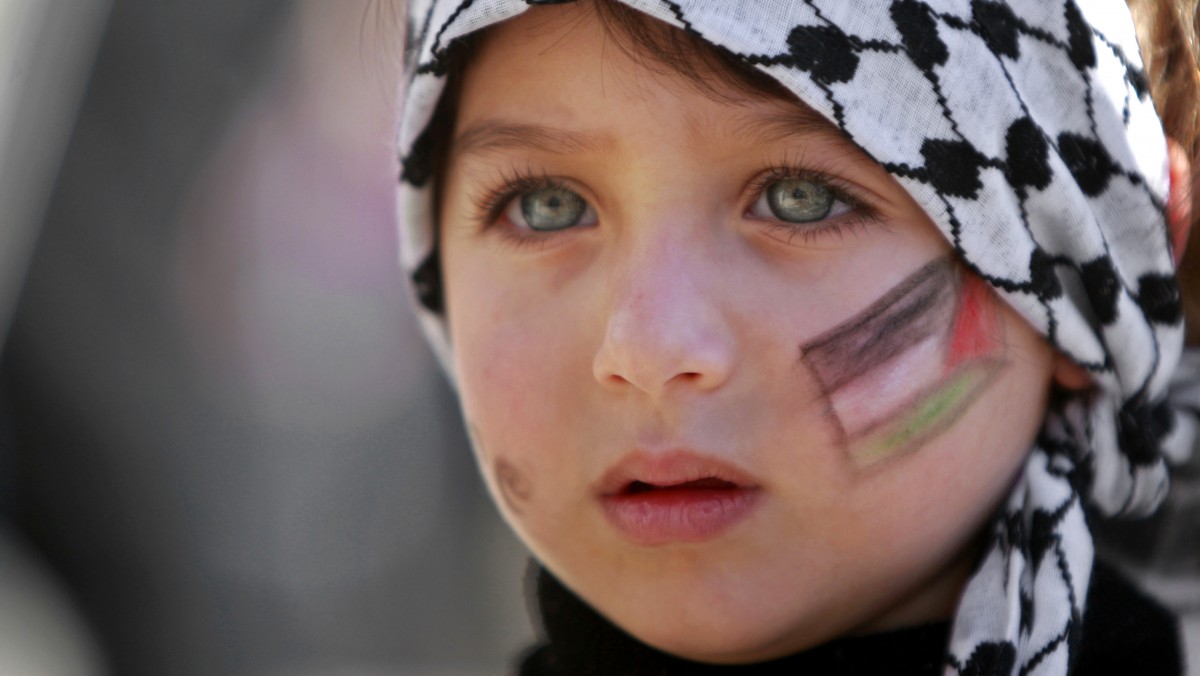 A girl with the Palestinian flag painted on her face attends a rally supporting the Palestinian UN bid for observer state status, in the West bank city of Ramallah, Thursday, Nov. 29, 2012. (AP Photo/Majdi Mohammed)