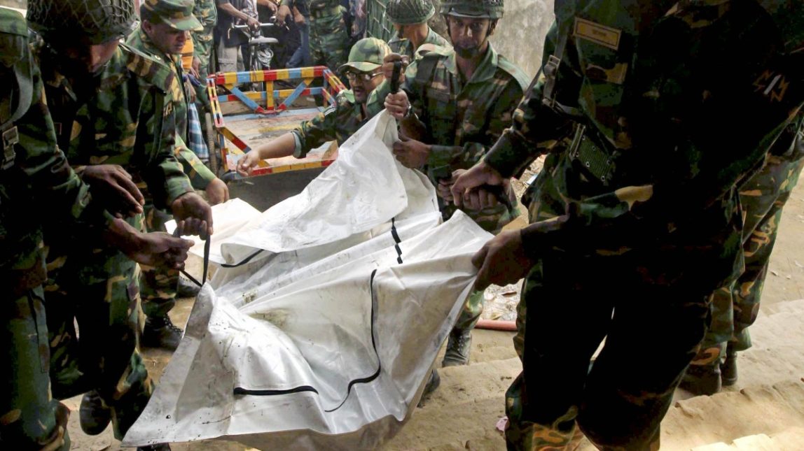 Bangladeshi army soldiers carry the bodies of workers died in a fire at a garment factory in the Savar neighborhood in Dhaka, Bangladesh, Sunday Nov. 25, 2012. (AP Photo/ Jibon Amir)