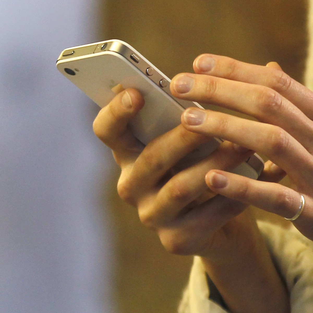 A woman uses her smartphone in central London, Wednesday, Nov. 14, 2012. UK Lawyers say the mounting tally of those arrested and convicted of making offensive comments through social media, shows the problems of a legal system trying to regulate 21st-century communications with 20th century laws. Civil libertarians say it is a threat to free speech in an age when the internet gives everyone the power to be heard around the world. (AP Photo/Sang Tan)